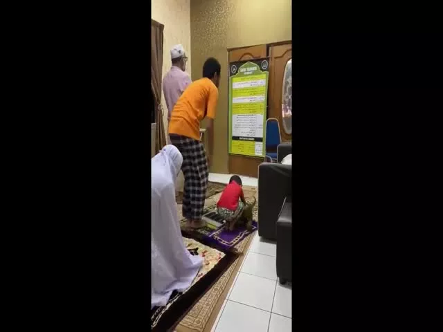 Boy Offering Namaz Prayers During Ramadan with His Toy