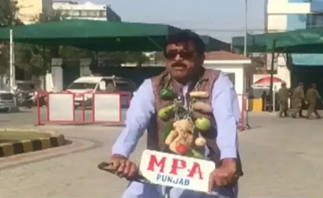 Pakistan MPA Tariq Masih Wore A Garland Made Of Potatoes Tomatoes And Capsicums To Protest Against The Rising Inflation In Pakistan - Sakshi