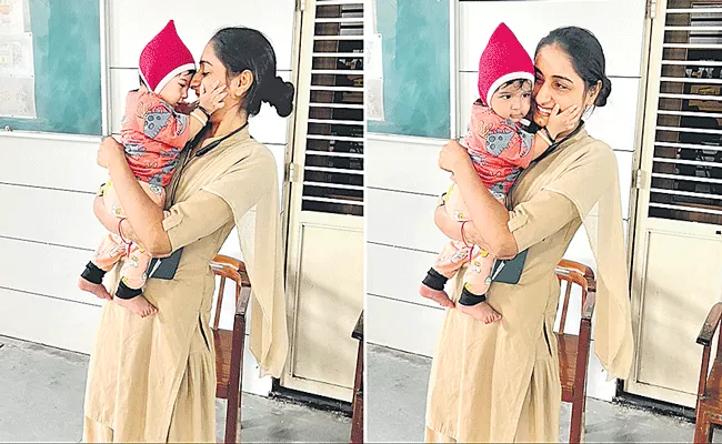 Ahmedabad constable babysits infant while mother writes Exam - Sakshi