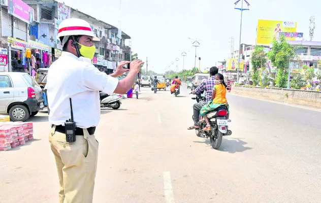 చలానా విధిస్తున్న ట్రాఫిక్‌ పోలీస్‌(ఫైల్‌) - Sakshi